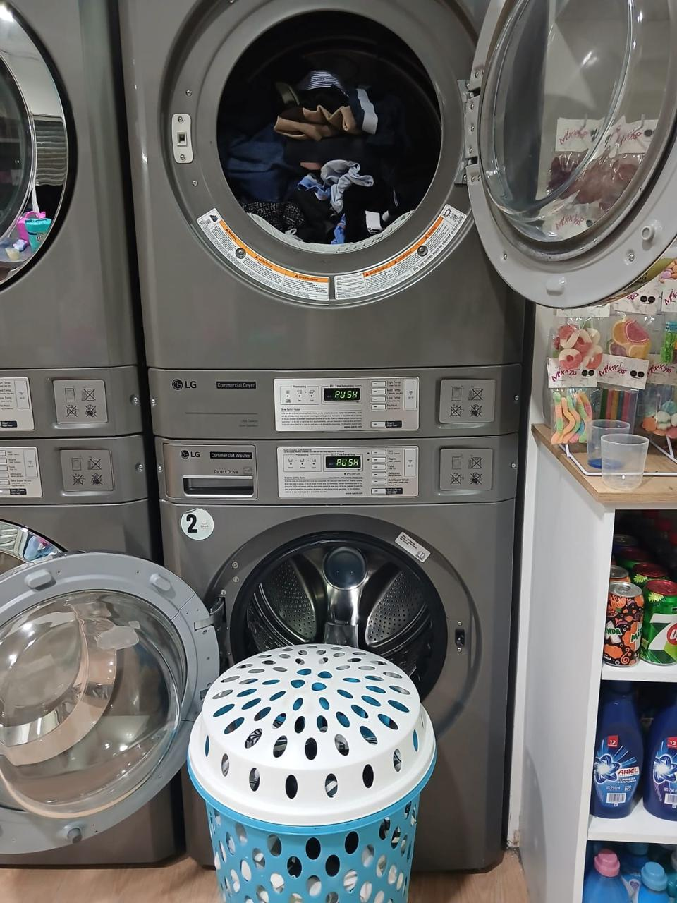 Carga de ropa junto a una lavadora comercial